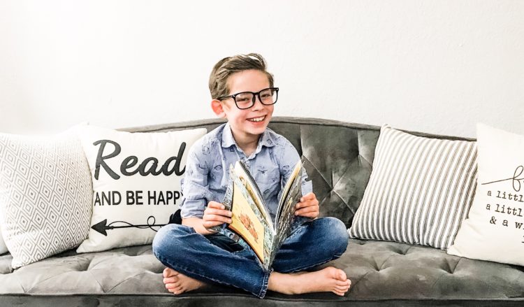 the author's son reading a book and smiling