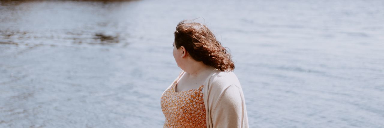 woman looking back at lake behind her