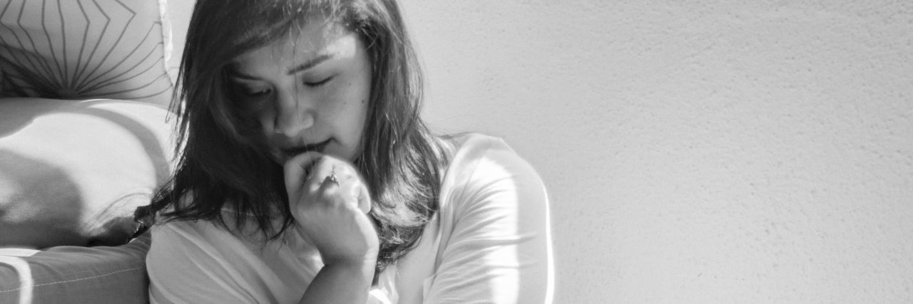 black and white photo of woman sitting on floor looking upset or concerned