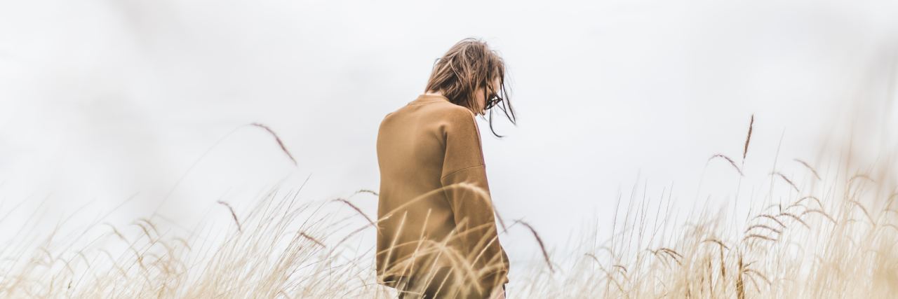 Being Unable to Have a Child Because of Illness: What It Feels Like woman standing in a wheat field, looking down