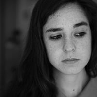 black and white photo of woman looking upset or sad and away from camera
