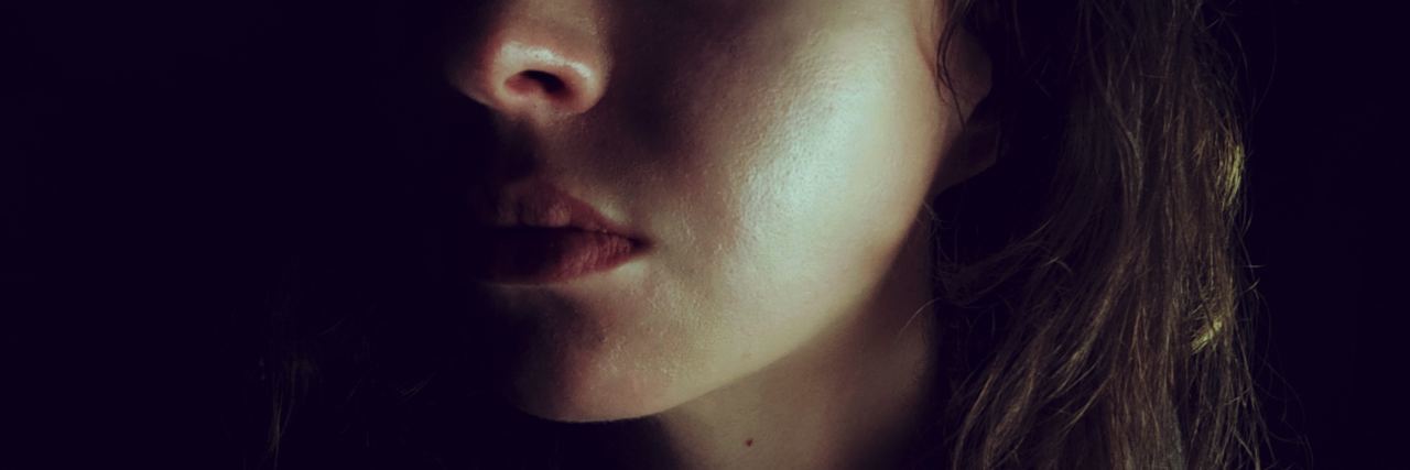 Struggling With Self-Doubt After an Abusive Relationship photo of woman in darkness looking sad