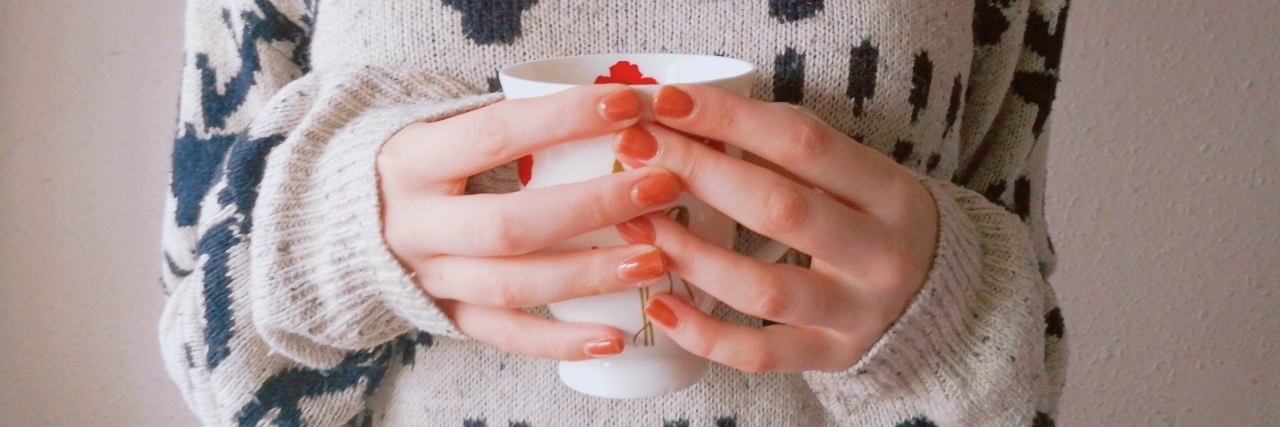 woman's hands holding cup