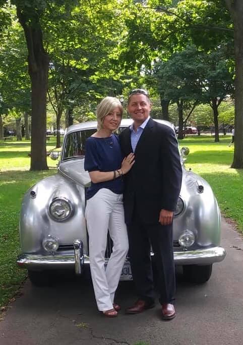 man and woman standing in front of rolls royce car
