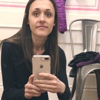 photo of contributor with anorexia looking at camera while sitting on floor of dressing room