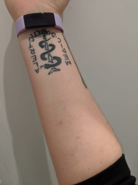 scars on arm with medic diabetic alert tattoo and purple activity watch