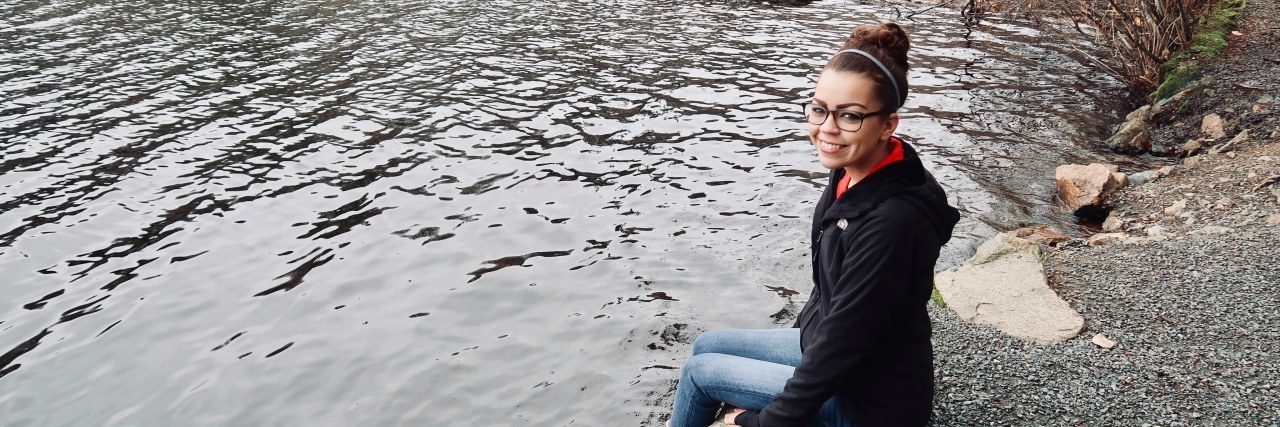 When People Say 'You Look Too Healthy to Be Disabled' Jennifer sitting by a lake.