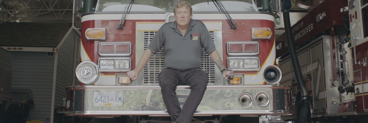 I Could Understand Losing My Fingers, but Not My Mental Health photo of retired firefighter Erik Bjarnason sitting on firetruck looking at camera