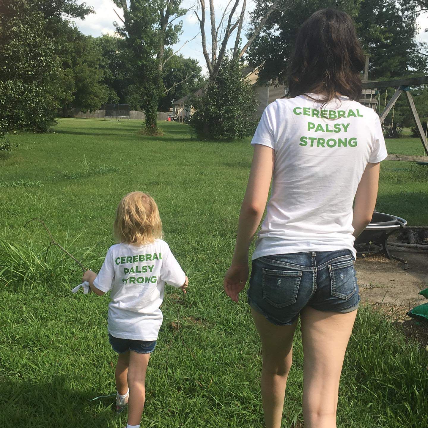 Megan's daughter with her mentor walking in the grass.