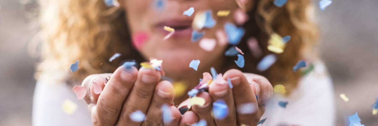 Overcoming the Stigma of Borderline Personality Disorder Woman cupping her hands and blowing confetti