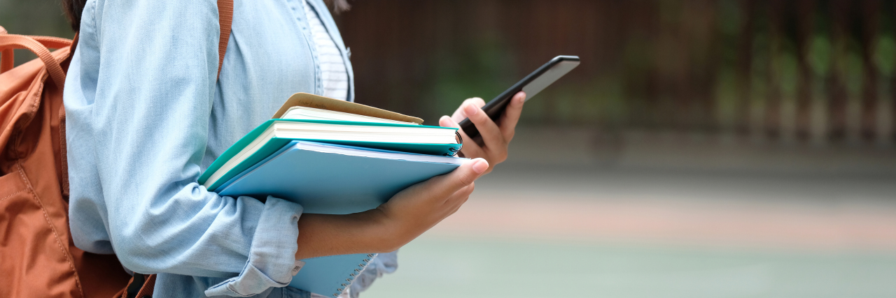 Attending University While Living With Misophonia: Advice woman holding books and phone with a book bag