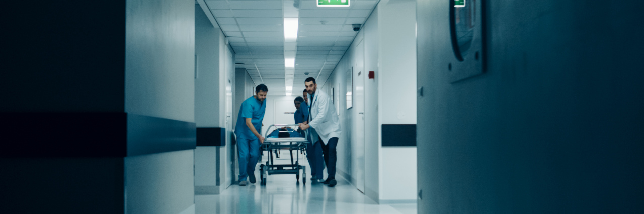 When a Doctor Dismissed My Symptoms and It Almost Killed Me Emergency Department: Doctors, Nurses and Surgeons Push Gurney / Stretcher with Seriously Injured Patient towards the Operating Room.