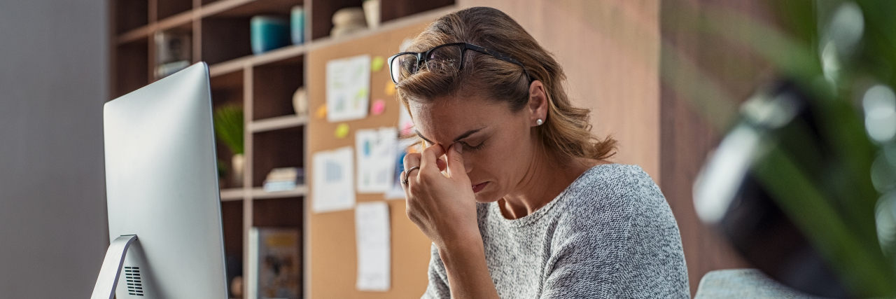 Epilepsy and Employment Discrimination Woman looking stressed at her office desk.