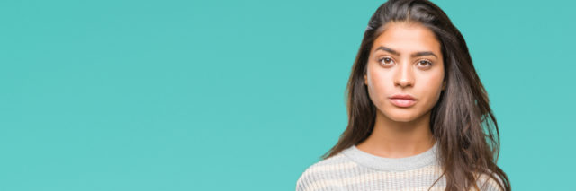 Indian woman against blue background in sweater