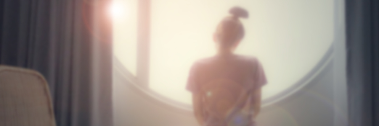 Trauma-Informed Therapy Helps You Start Living Abstract blurred of woman sitting looking through a window.