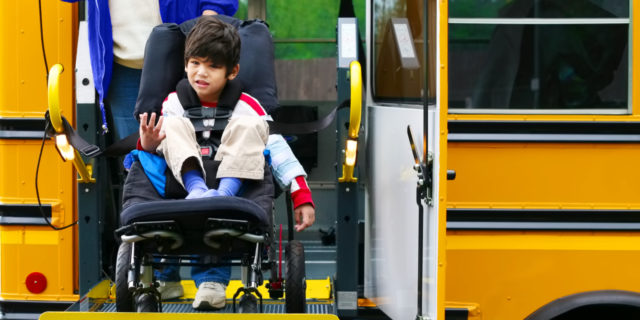 To Children With Cerebral Palsy Going Back to School Boy in wheelchair on bus lift.