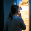 Sleepy woman looking in refrigerator.