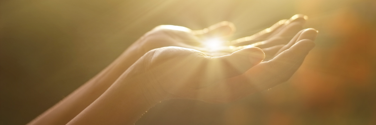 Path to Acceptance of Bipolar Disorder Diagnosis A woman's hands stretched out, palms down among a sunny backdrop