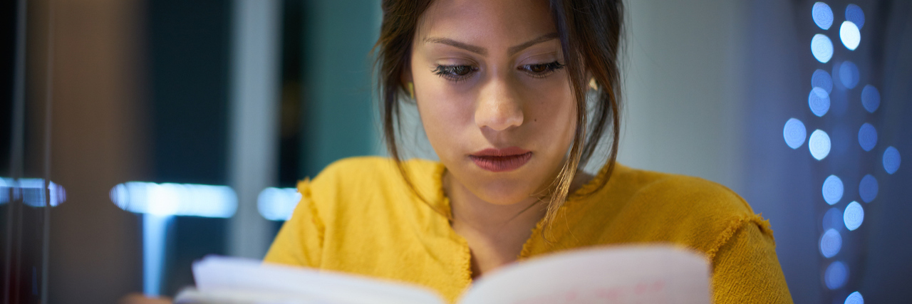 Addressing and Accepting My PTSD: Symptoms and Treatment Woman writing in notebook at night