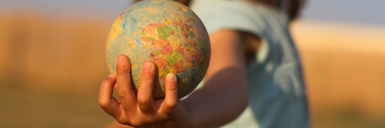 Close-up of a child holding a small globe