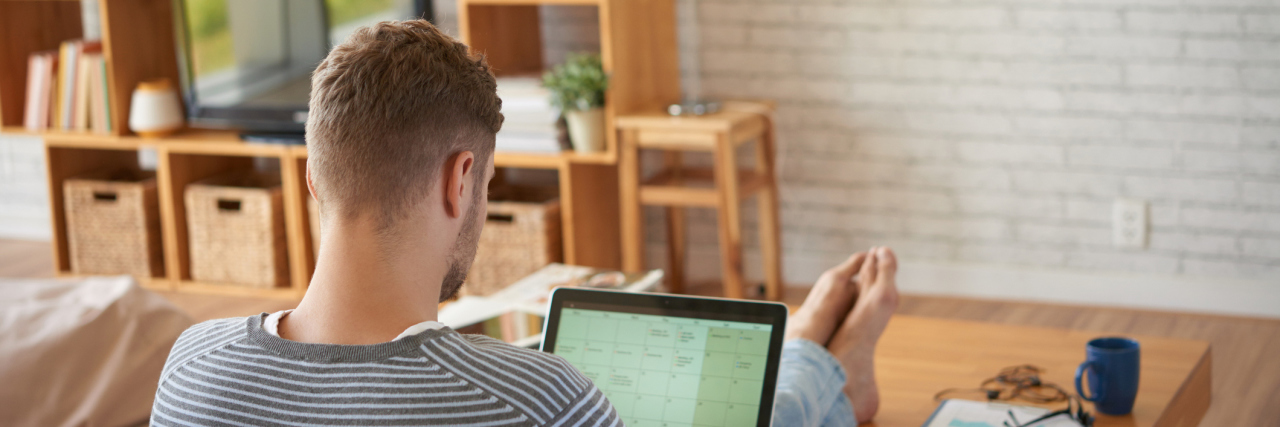 My Best Life Hacks for Living With ADHD Rear view of businessman sitting on sofa at home and planning his work