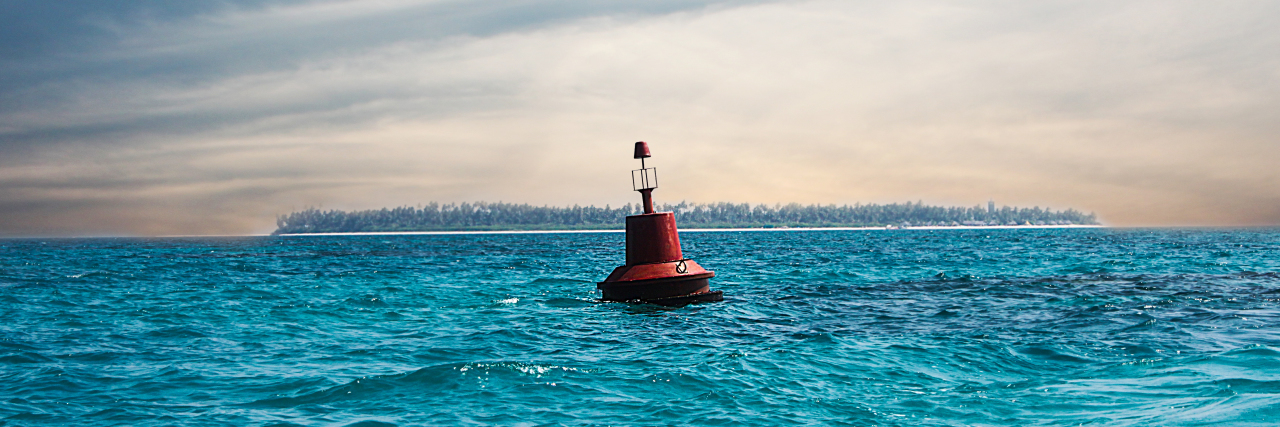 A red buoy floats in the ocean.