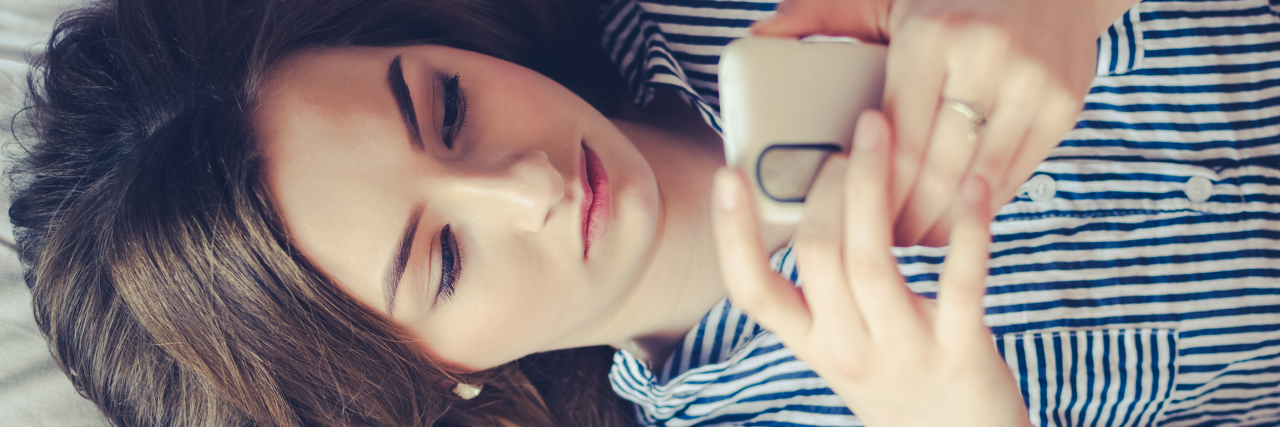 Deleting Messenger Apps When Borderline Makes Me Think People Hate Me close up photo of young woman lying on bed with phone, taken overhead
