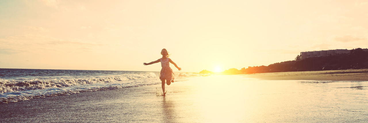 The Joys and Challenges of Family Visits With a Disability Happy little girl running on the beach.