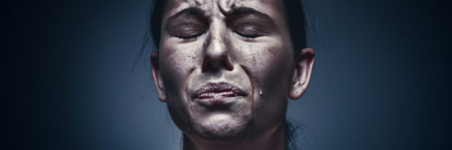 close up portrait of crying woman with eyes closed