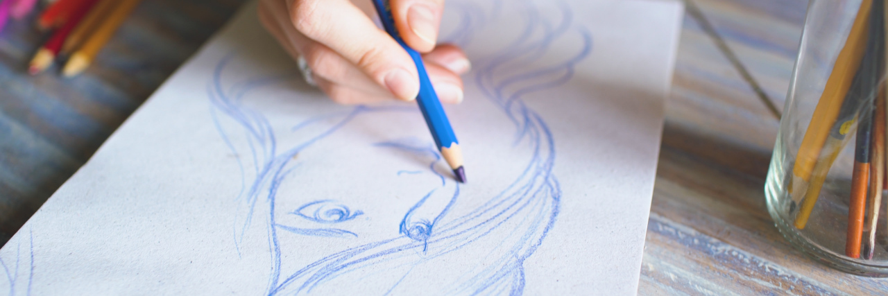 Reclaiming My Life as a Young Adult With Myalgic Encephalomyelitis Closeup of female hand painting sketch on paper.