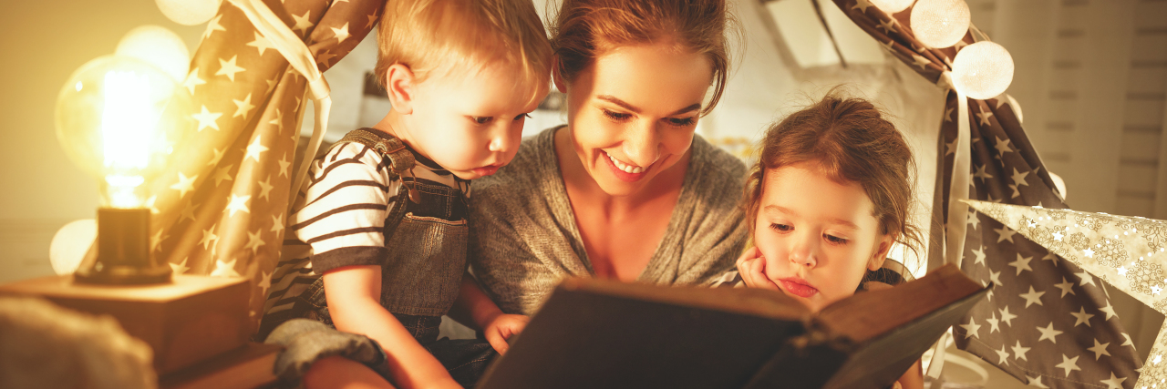 How Storytelling Can Help Children With Autism Mother and children reading a book.