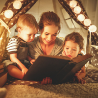 Mother and children reading a book.