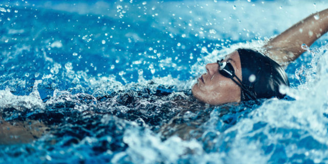 A woman swimming the backstroke in a pool