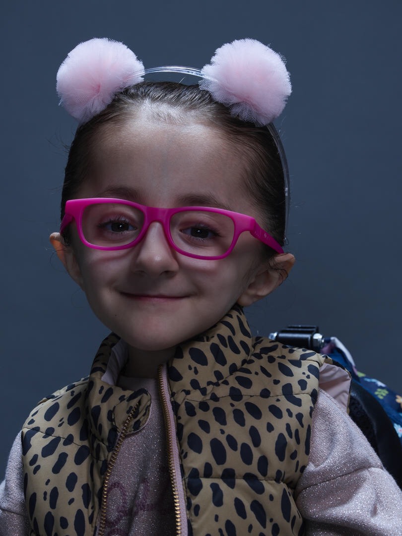 Sammi Haney, wearing cute pink glasses and a headband with pink ears on it.