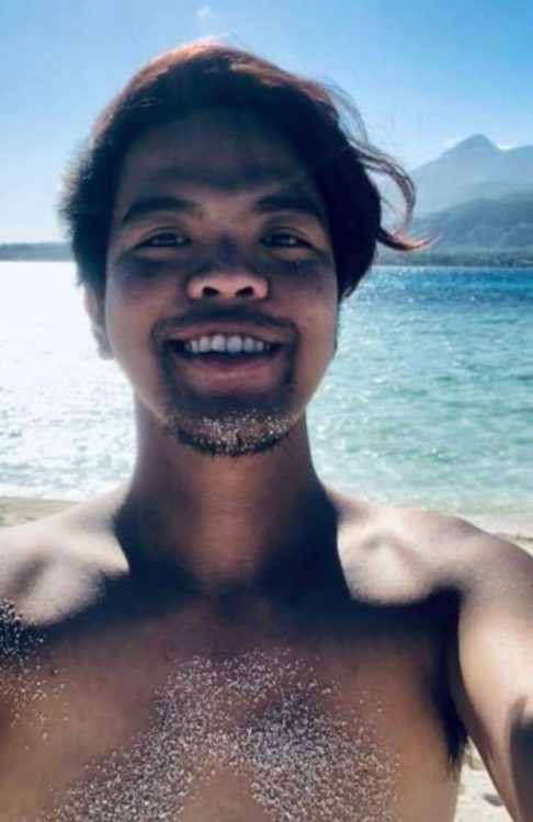 man smiling selfie at the beach