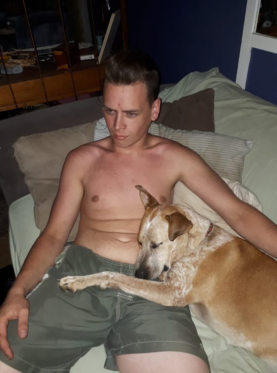 shirtless man cuddling with a dog
