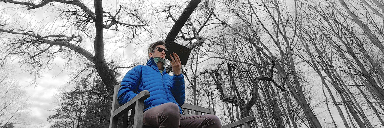 The Resonance Project for Musicians With Chronic Illness, Disability A man wearing a neck brace sitting in the forest. Text reads "The Resonance Project. From the pain of many, a song."