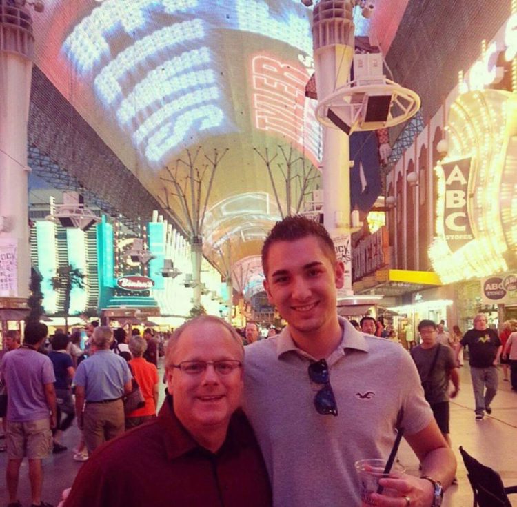 Father and son in Las Vegas smiling with arms around each other