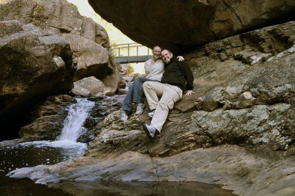 couple smiling while posing on rocks