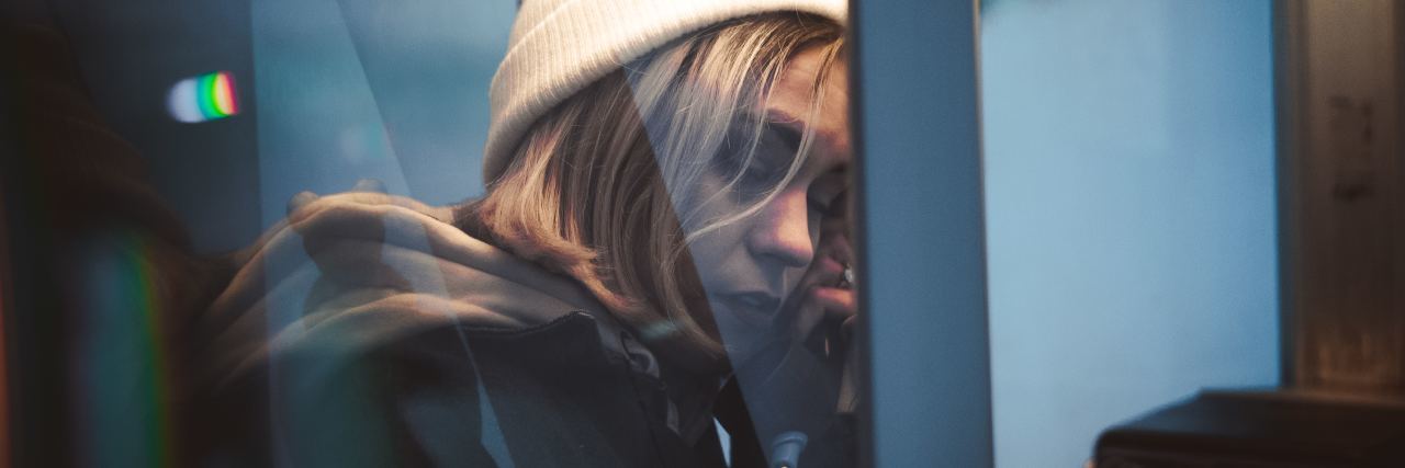 The Problems With Australia's Suicide Prevention Day, 'R U OK?' Day photo of young woman holding public phone to ear in phone box