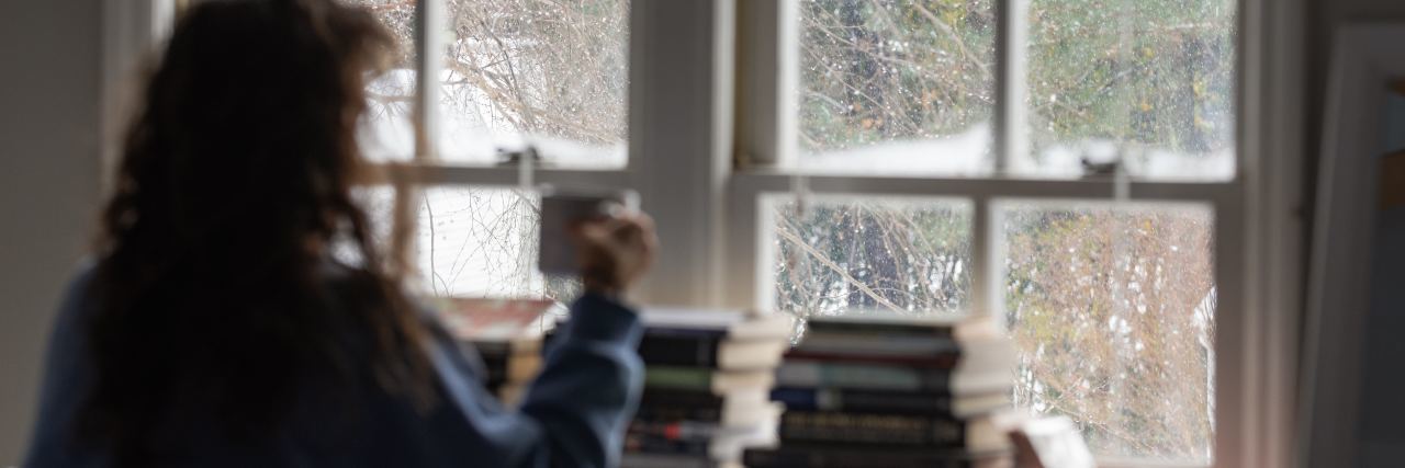 Using Distractions to Cope With Bipolar Disorder photo of woman with coffee and books looking out of window