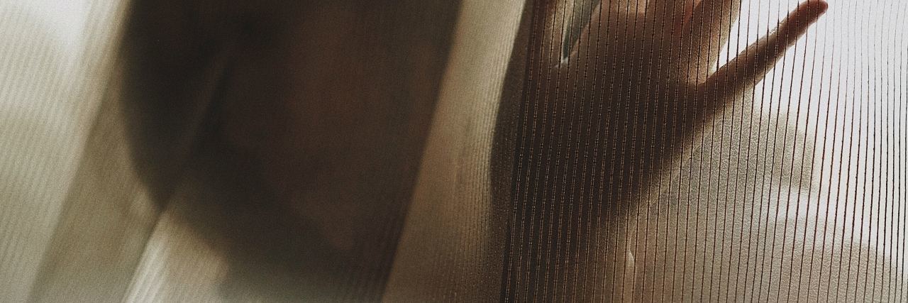 What to Know at the Start of Your Chronic Pain photo of woman behind curtain with hand raised