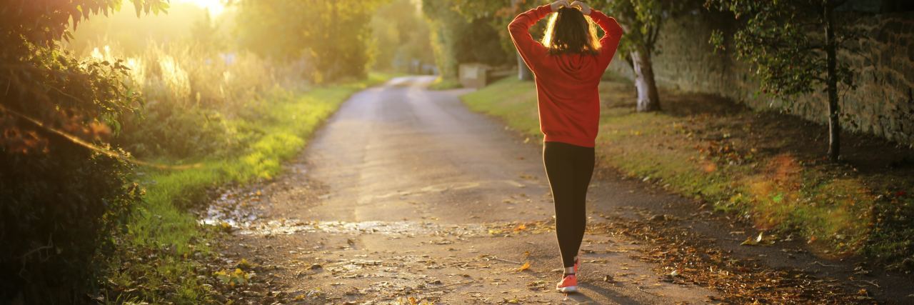 Read This If You Feel Like Nobody Understands Your Bipolar Disorder photo of young woman walking down country lane alone at sunrise
