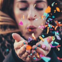 close up photo of woman blowing confetti