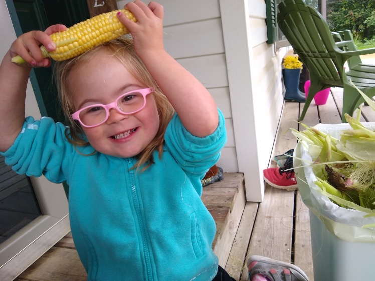 Willow holding an ear of corn on her head.