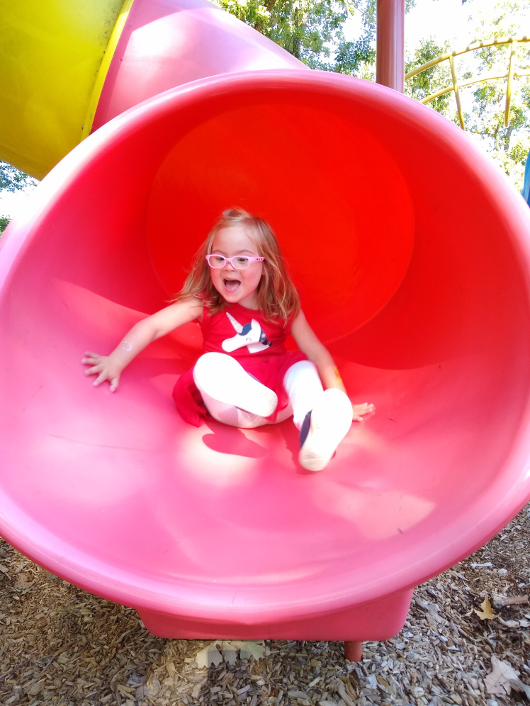 Willow playing in a pink tube slide.