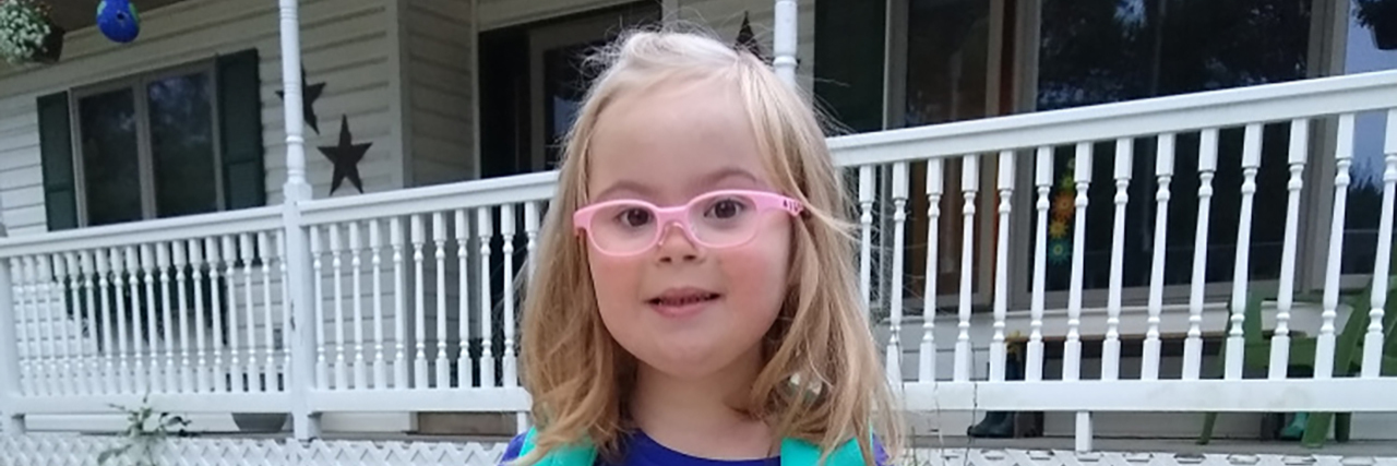 Sending My Daughter With Down Syndrome to Kindergarten Willow in her pink glasses and backpack ready for school.