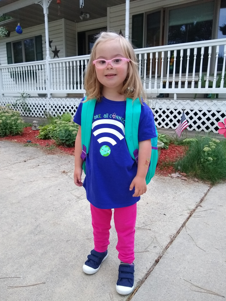Willow in her pink glasses and backpack ready for school.