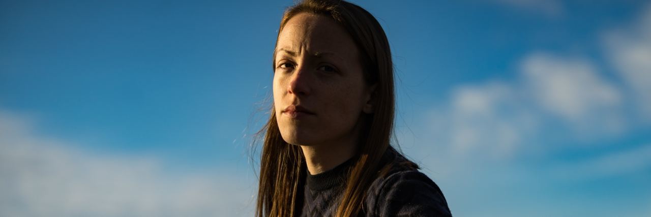 'Secrets' Mental Health Counselors Want You to Know photo of woman against blue sky looking serious into camera