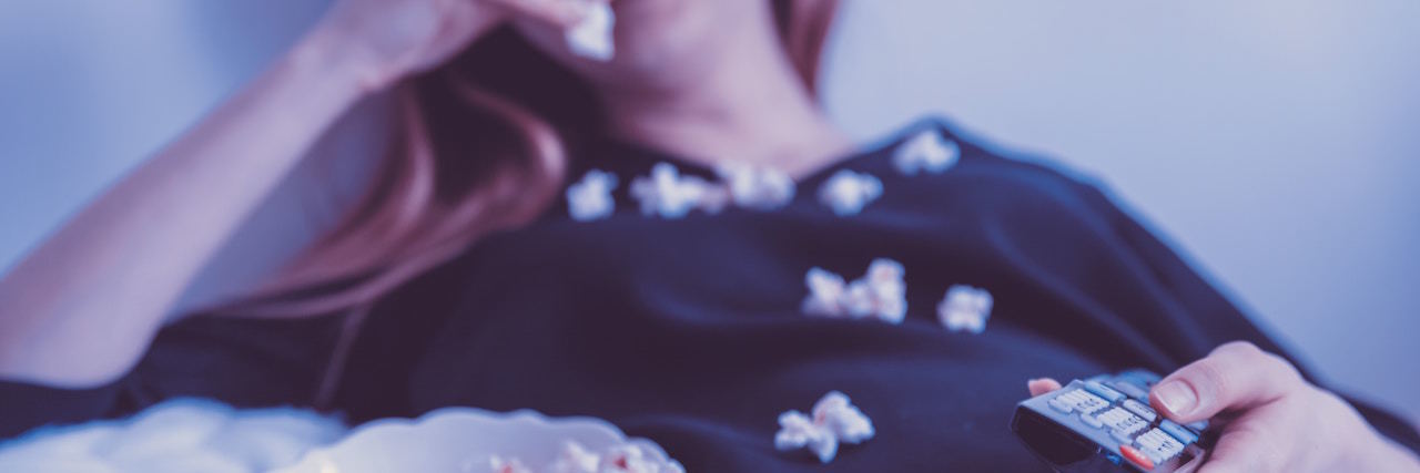 Woman watching movie and eating popcorn